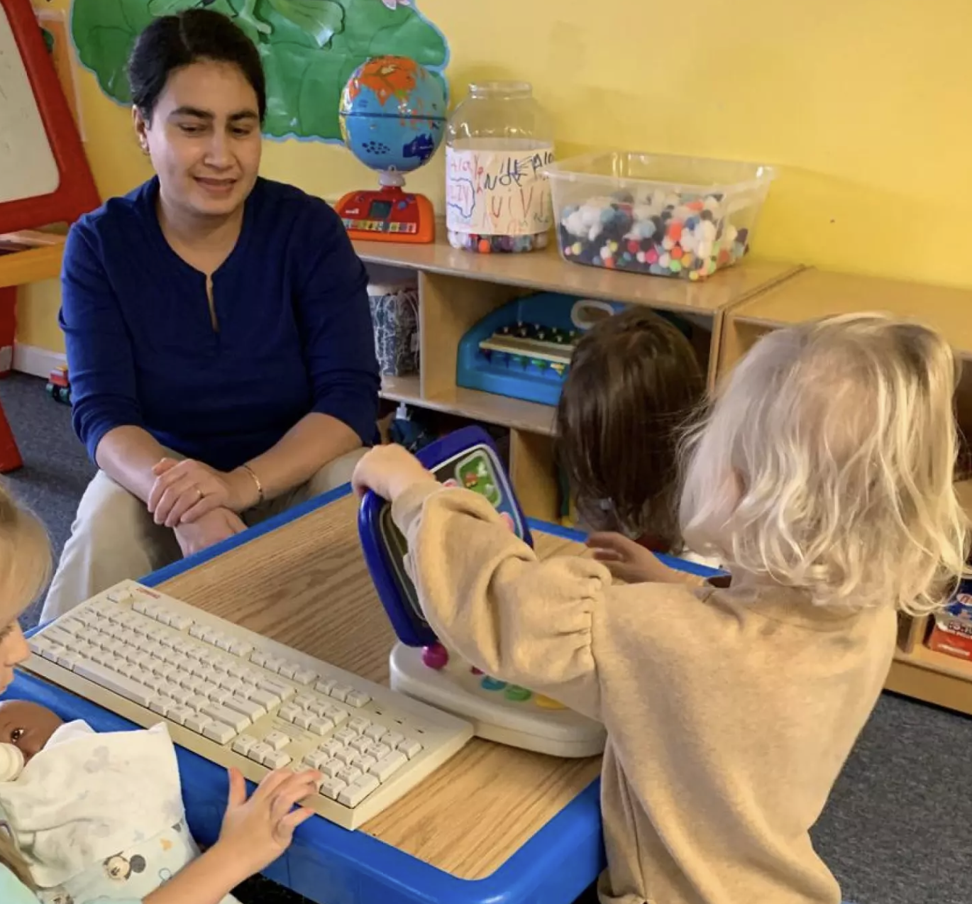 Woman in a daycare environment with small children.