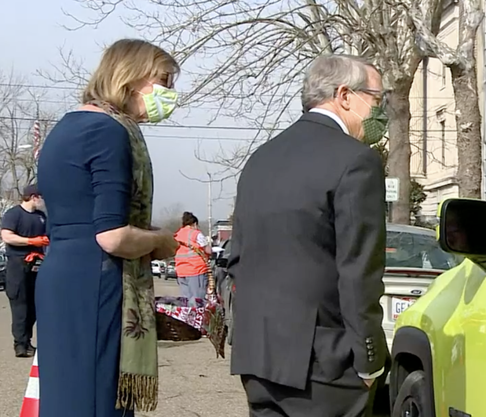 Governor DeWine and wife talk to people in a car.